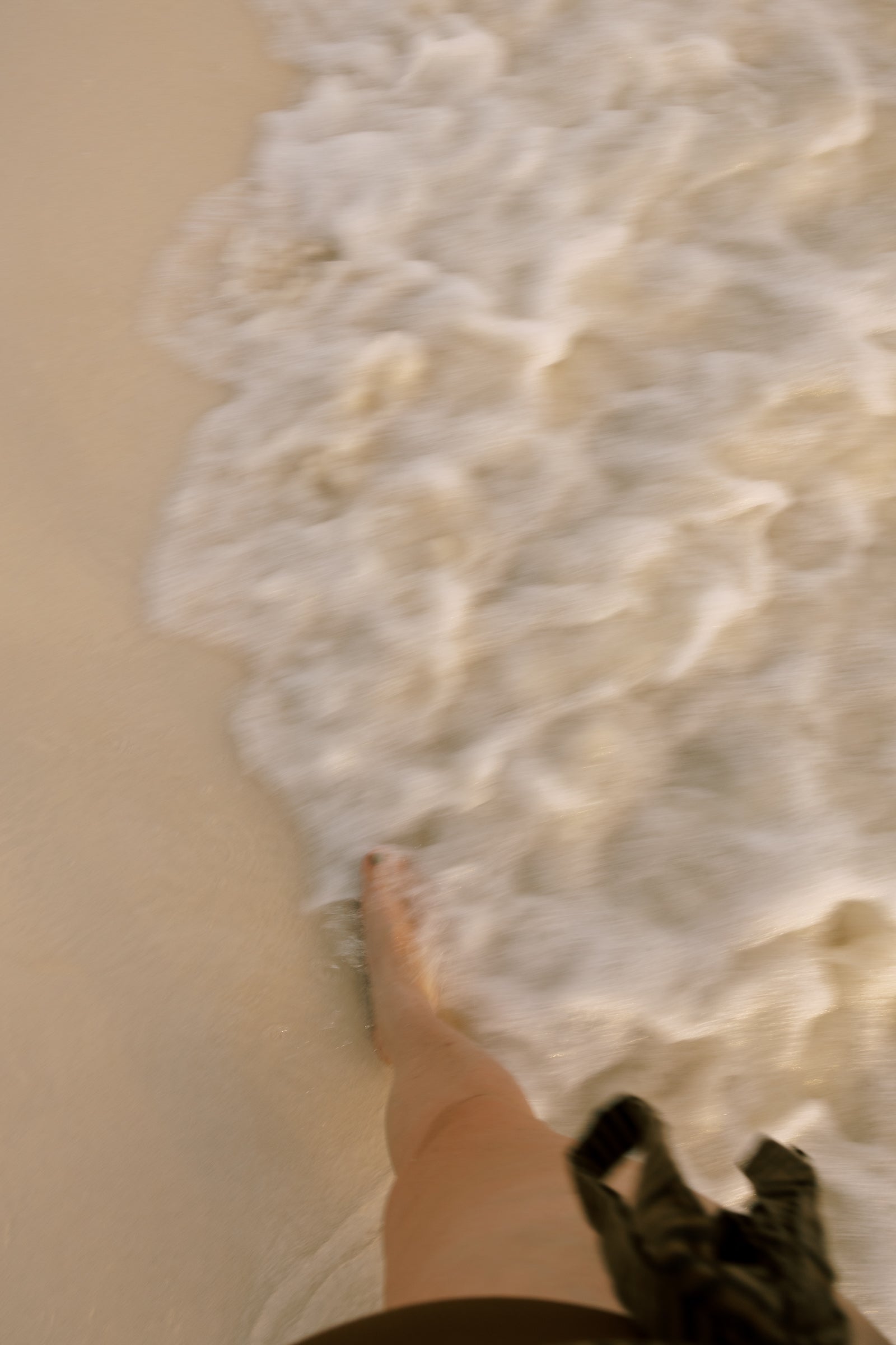 Barefoot woman walking through ocean waves, symbolizing flow, softness, and the start of a soul-led business journey.